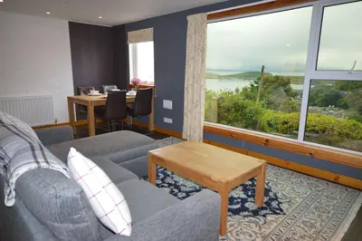 a living room with a couch and a large window at Ardura Apartment No 1 in Oban