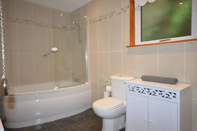a bathroom with a toilet and a shower and a sink at Ardura Apartment No 2 in Oban