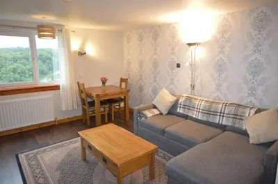 a living room with a couch and a table at Ardura Apartment No 2 in Oban