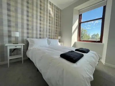 a bedroom with a bed with two towels on it at The Haven in Greenock