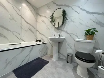 a bathroom with a toilet and a sink and a bath tub at The Haven in Greenock