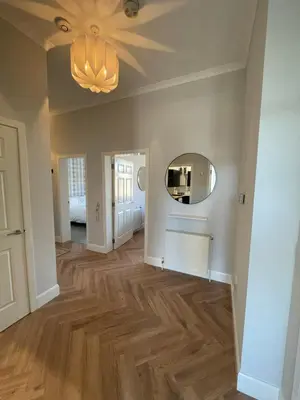 a hallway of a home with a mirror and wood floors at The Haven in Greenock