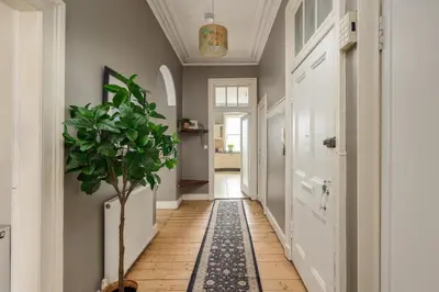 a hallway with a potted plant on a tile floor at 2 Bed Old Town Apartment - Next To Castle in Edinburgh