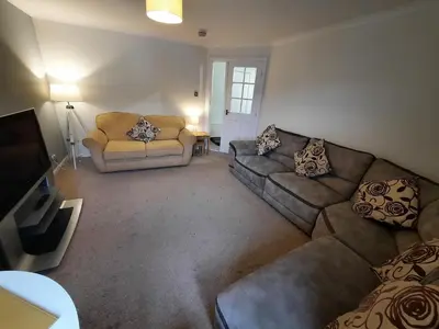 a living room with two couches and a television at Ardfern Apartments in Airdrie
