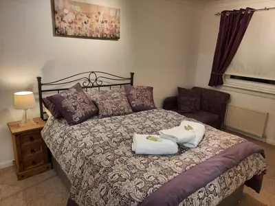 a bedroom with a bed with two pillows on it at Ardfern Apartments in Airdrie