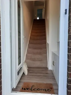 a hallway with stairs with a rug on the floor at Ardfern Apartments in Airdrie