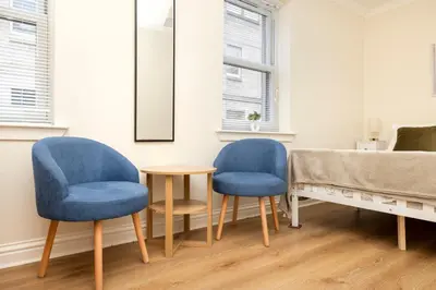 two blue chairs and a table in a room at JOIVY Lovely Flats near the City Centre in Edinburgh