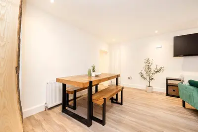a dining room with a table and a couch at JOIVY 3BR Flat in Haymarket with Free Parking in Edinburgh