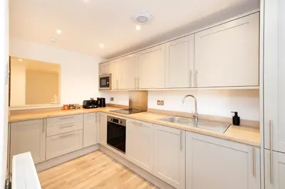 a kitchen with white cabinets and a sink at JOIVY 3BR Flat in Haymarket with Free Parking in Edinburgh