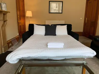 a bed in a living room with a large mattress at JOIVY Adorable flat near West End in Edinburgh