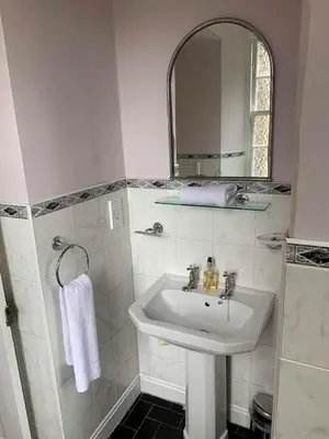 a white bathroom with a sink and a mirror at JOIVY Adorable flat near West End in Edinburgh