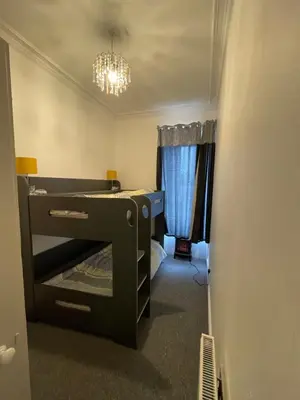 a small bedroom with a bunk bed and a chandelier at Spacious 3 Bedroom Entire Apartment Self Check in in Fife