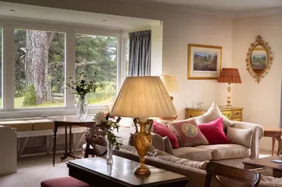 a living room with a couch and a table at Lochs Lodge, Glenlyon, Perthshire in Bridge of Balgie
