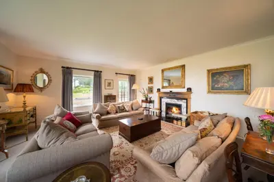 a living room with two couches and a fireplace at Lochs Lodge, Glenlyon, Perthshire in Bridge of Balgie