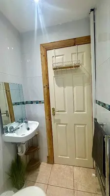 a bathroom with a sink and a door with a mirror at 4B Millhill Street in Dunfermline