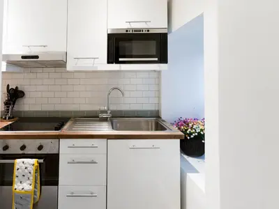 a kitchen with white cabinets and a sink at West End Studio Kelvingrove Park Museum - Pass the Keys in Glasgow