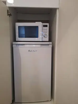 a microwave sitting on top of a refrigerator at Castleview is a lovely flat in a listed building in Rothesay