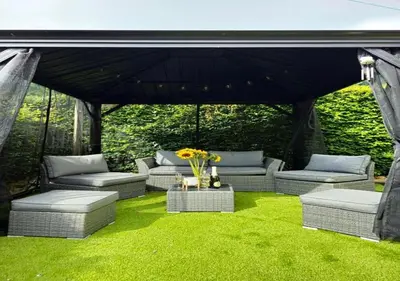 a gazebo with couches and a table with flowers at Gleann Fia House in Arrochar