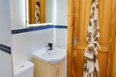 a bathroom with a sink and a toilet and a mirror at Gleann Fia House in Arrochar