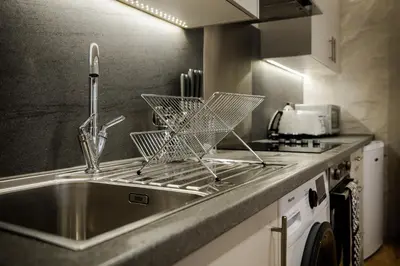 a kitchen sink with a dish drying rack on it at 2 BDR House At Caledonia Luxe Stays Short Lets & Serviced Accommodation Crieff in Crieff