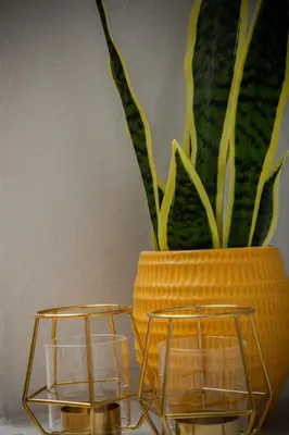 a yellow vase with a plant and two candle holders at 2 BDR House At Caledonia Luxe Stays Short Lets & Serviced Accommodation Crieff in Crieff