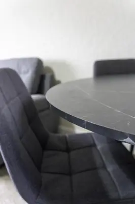 a table and a black chair and a couch at Raploch House in Larkhall