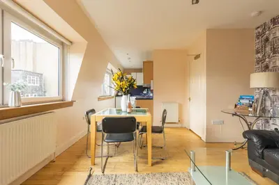a dining room and living room with a table and chairs at Amazing Castle View Apartment in Edinburgh