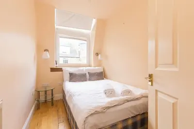 a small bedroom with a bed and a window at Amazing Castle View Apartment in Edinburgh