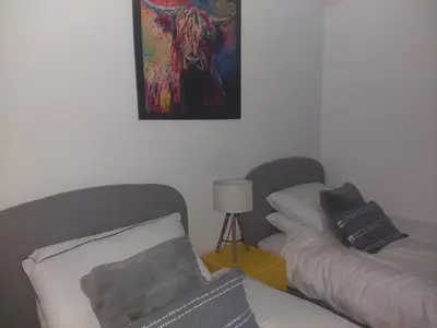 a living room with a bed and a painting on the wall at the waterside - carrick castle - loch goil in Carrick