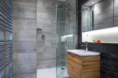 a bathroom with a sink and a glass shower at Magnificent Georgian 3-Bedroom Apartment in New Town in Edinburgh