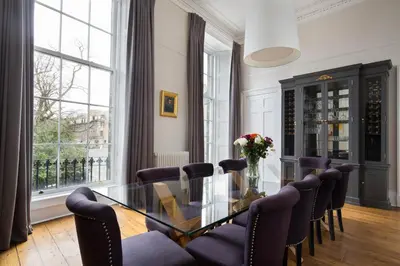 a dining room with a glass table and chairs at Magnificent Georgian 3-Bedroom Apartment in New Town in Edinburgh