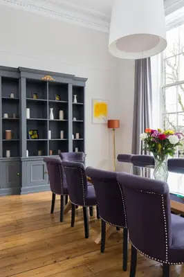 a dining room with blue chairs and a table at Magnificent Georgian 3-Bedroom Apartment in New Town in Edinburgh