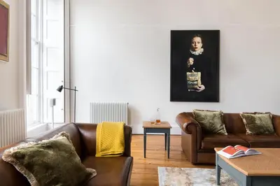 a living room with two brown couches and a table at Magnificent Georgian 3-Bedroom Apartment in New Town in Edinburgh