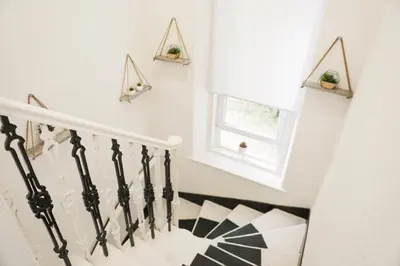 a staircase with white walls and a window with plants at Glasgow, Bothwell, 3 bed, Suitable for Long Stays in Bothwell