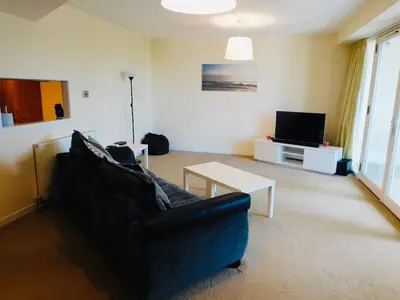 a living room with a couch and a tv at No 2 - Modern 2 Bed Apartment Close to Gla Airport & M8 in Paisley