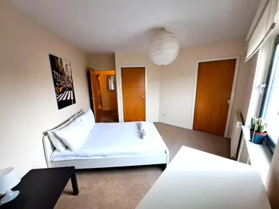 a bedroom with a white bed and a table at No 2 - Modern 2 Bed Apartment Close to Gla Airport & M8 in Paisley