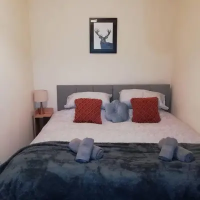 a bedroom with a bed with two stuffed animals on it at Carvetii - Norman House - 2nd floor, 1 bedroom flat in Boʼness