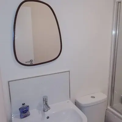 a bathroom with a sink and a mirror over a toilet at Carvetii - Norman House - 2nd floor, 1 bedroom flat in Boʼness