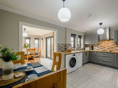 an open kitchen and dining room with a table and a washer at Westertonhill Lodge - 3 Double Bedrooms Sleeps 8 With Private Hot Tub Hire Available in Balloch