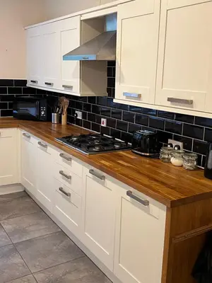a kitchen with white cabinets and a stove top oven at Victorian 3 BR main door flat, King size beds , large rooms in Glasgow
