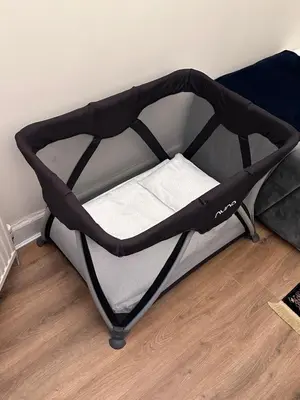 a black bed frame with a small white pillow on it at Victorian 3 BR main door flat, King size beds , large rooms in Glasgow