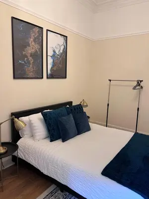 a bedroom with a large bed with blue pillows at Victorian 3 BR main door flat, King size beds , large rooms in Glasgow