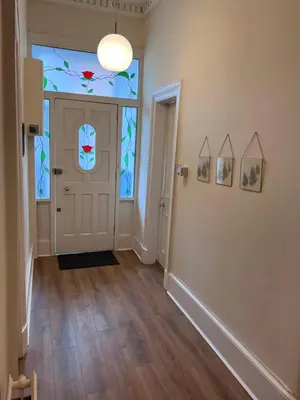 a hallway with a door with stained glass at Victorian 3 BR main door flat, King size beds , large rooms in Glasgow