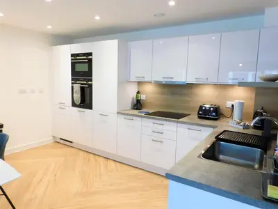 a kitchen with white cabinets and a sink at Brand new gorgeous 2 bed Apt in Finnieston in Glasgow