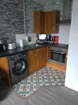 a kitchen with a washing machine and a washer at Moorburn Heights in Largs