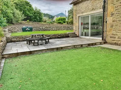 a patio with a picnic table in a yard at Laburnam Villa - Luxury 4 bedroom accommodation in the heart of Killin in Killin