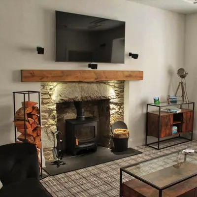a living room with a fireplace with a television above it at Laburnam Villa - Luxury 4 bedroom accommodation in the heart of Killin in Killin