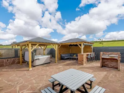 a patio with a gazebo and a picnic table at Westertonhill Newbuild Lodges with Private Hot Tub Hire Available in Balloch