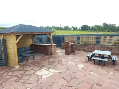 a patio with a gazebo and a picnic table at Westertonhill Newbuild Lodges with Private Hot Tub Hire Available in Balloch