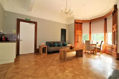 a living room with a couch and a table at Signature - Linden House Flat 1 in Airdrie